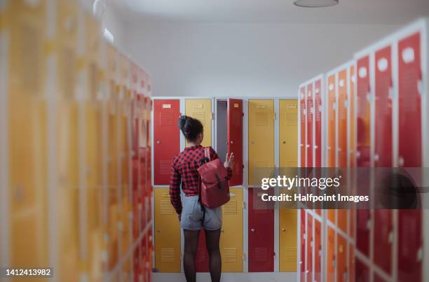 rear view of teenage girl in locker room. - rode korte broek stockfoto's en -beelden