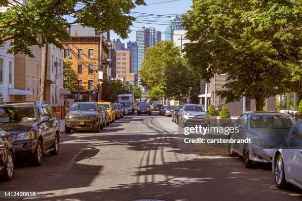 view down a street with old wooden residential buildings towards an area with modern high rise buildings - general images of property stock pictures, royalty-free photos & images