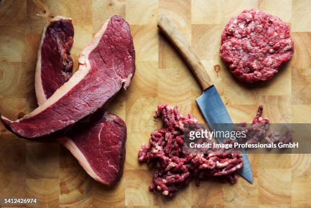 beef steaks, minced meat and a beef patty with a knife on a chopping board - steak rind bildbanksfoton och bilder