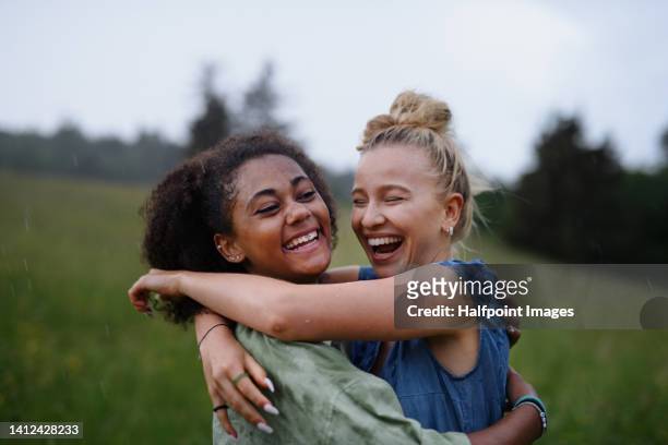 happy teenage girls outdoor, standing and enjoying rain. - happy laugh stockfoto's en -beelden
