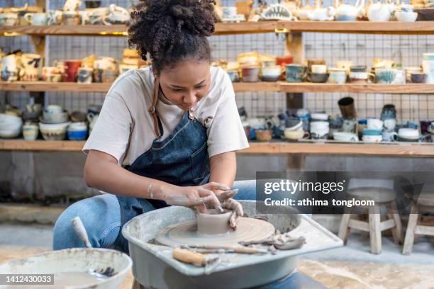 female potter working with clay on a pottery wheel. - torno de oleiro imagens e fotografias de stock