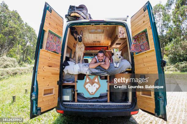 man with dog in motorhome looking at the sea - camping trailer stock pictures, royalty-free photos & images