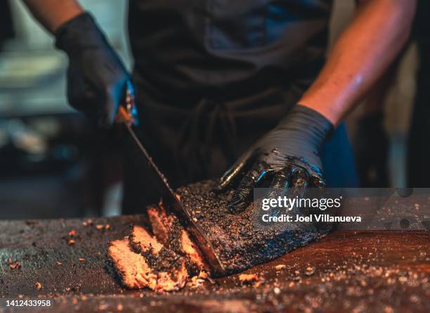 bbq chef cuts deliciously tender smoked brisket slices. - texas stockfoto's en -beelden