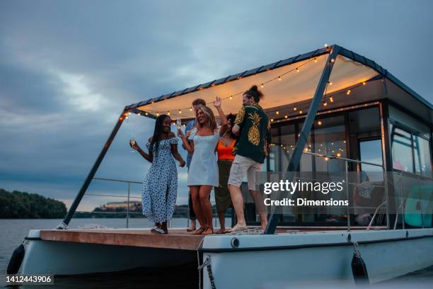 les jeunes adultes font la fête lors d’une croisière fluviale - catamaran race photos et images de collection