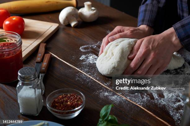 cooking italian vegetarian pizza with vegetables and mushrooms at home, pizzeria or cafe. a woman baker, pastry chef or cook kneads and rolls the dough with her hands, in a bakery. the concept of food. step-by-step instructions, do it yourself. step 1. - pizza ingredient stock pictures, royalty-free photos & images