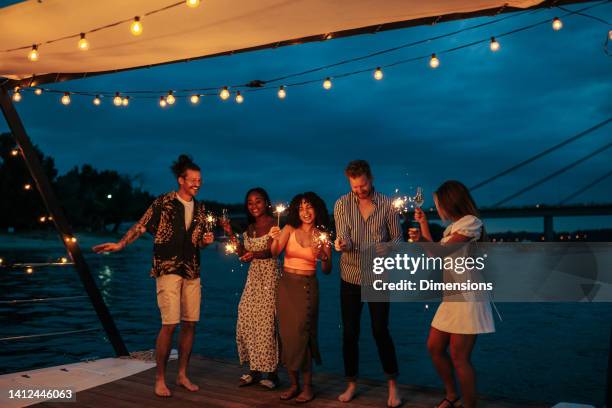 multiracial smiling friends enjoying on the boat - party imagens e fotografias de stock