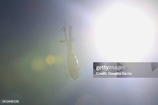 overhead helicopter seen through the sun glare - helicopter rotors stock-fotos und bilder