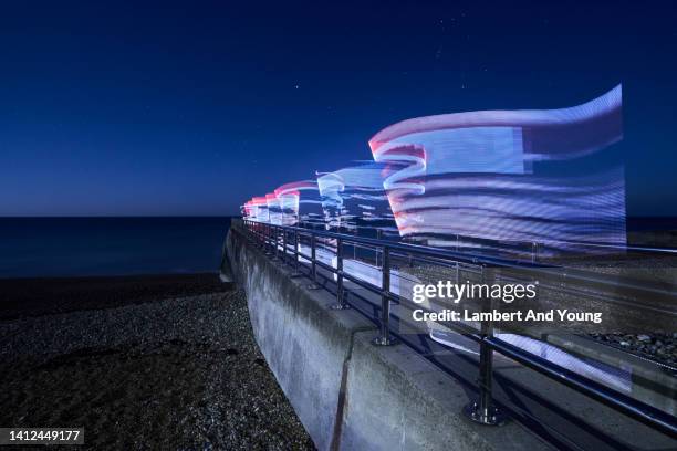 fragmented light trail fading off in to the sea - magic swirl stock pictures, royalty-free photos & images