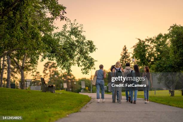 university students walking outside on campus - campus stockfoto's en -beelden