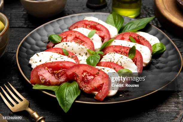 caprese-salat mit mozzarella, tomaten und basilikum - mozzarella stock-fotos und bilder
