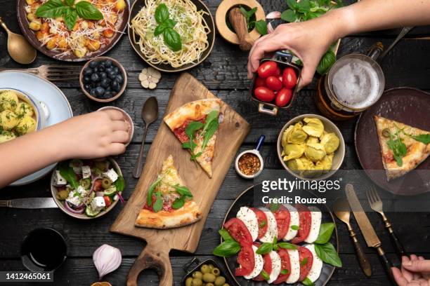 flat-lay of family dinner table with italian food - italien food stock pictures, royalty-free photos & images