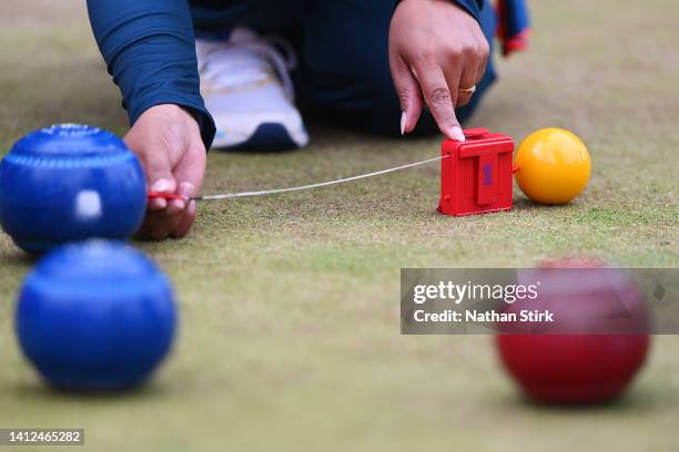 Match official measures the distance between bowls during Women's Fours - Gold Medal Match between South Africa and India on day five of the...