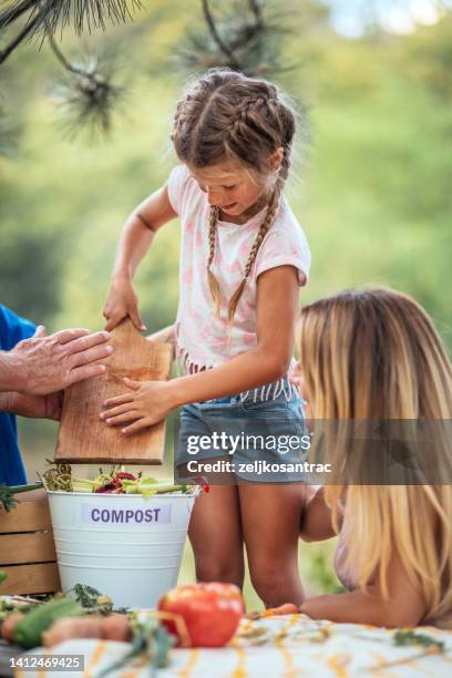 family composting kitchen waste outdoors - daily bucket imagens e fotografias de stock