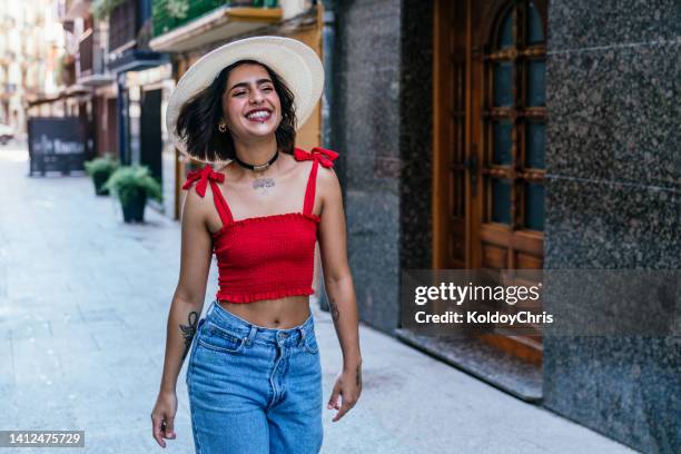 a cheerful young woman walking through the city - clumsy walker stock pictures, royalty-free photos & images