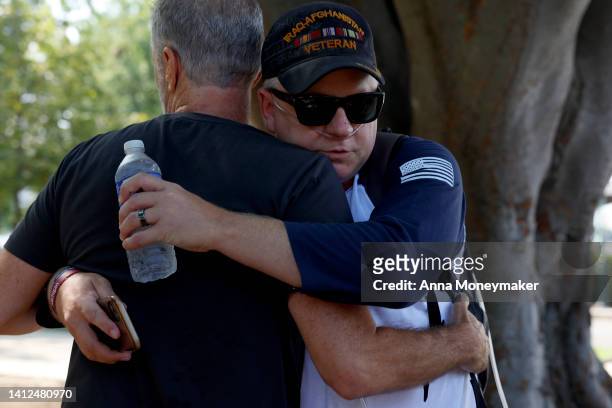 Comedian and activist Jon Stewart hugs a Kevin Hensley, an Iraq and Afghanistan war veteran, at a demonstration for the PACT act outside the U.S....