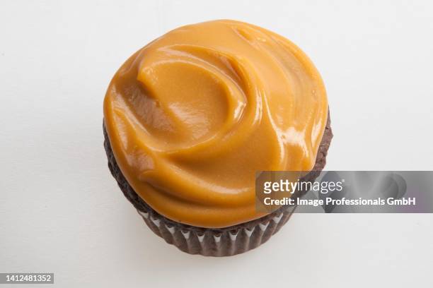 a chocolate cupcake topped with butterscotch pudding - butterscotch stock pictures, royalty-free photos & images