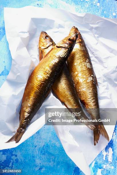 smoked kippers on a piece of paper - kipper stock pictures, royalty-free photos & images