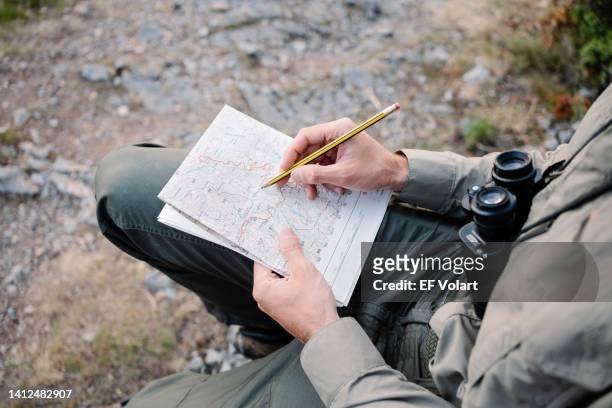 man hands checking topographic mountain map, examining route to explore nature - parkvakt bildbanksfoton och bilder