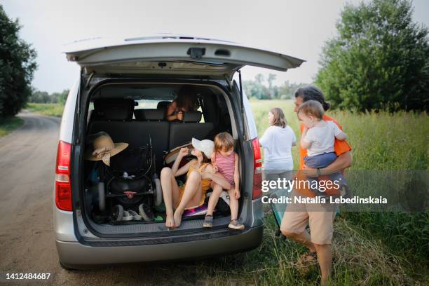 crazy funny kids sisters play in trunk large car in summer trip, dad and child loading suitcase into car - bizarre stock pictures, royalty-free photos & images