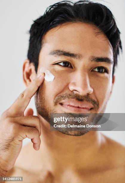 fresh skincare, face cream and healthy skin product on handsome man for grooming, moisturizing and hydration. closeup headshot of model on grey studio background applying sunscreen for sun protection - artists model stock pictures, royalty-free photos & images