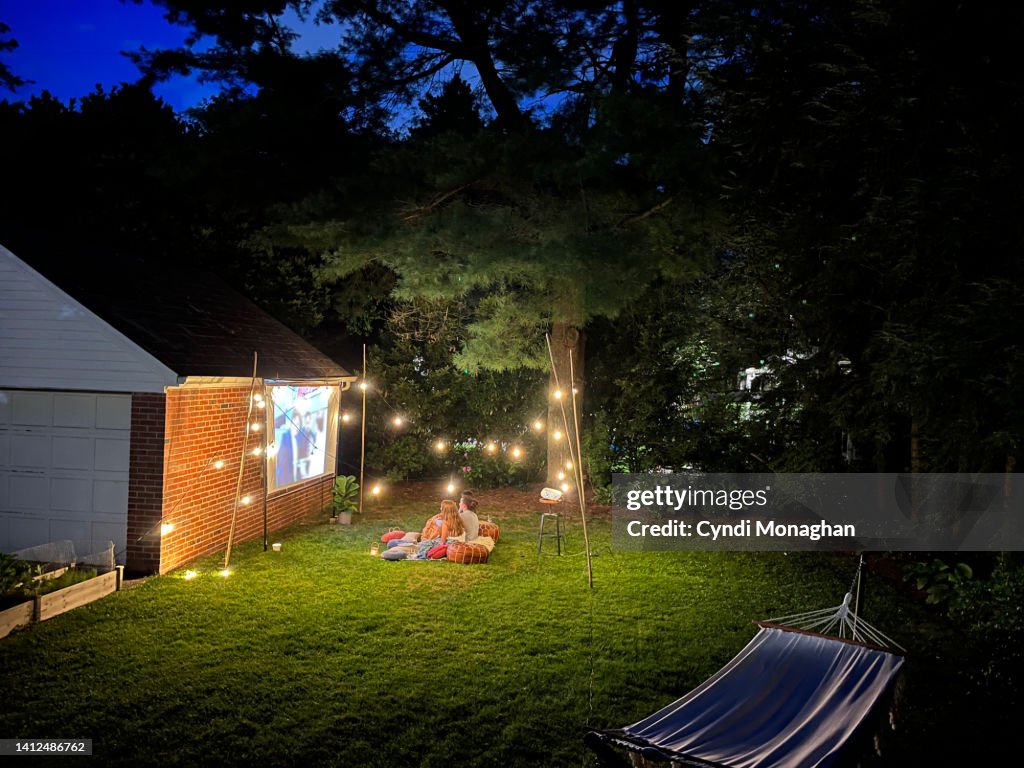 Friends snuggled on a blanket for outdoor movie night