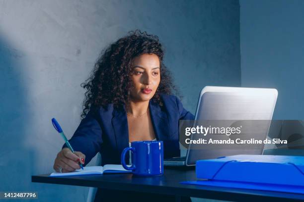 black woman working in an office, in front of a laptop - amanda blue stock pictures, royalty-free photos & images