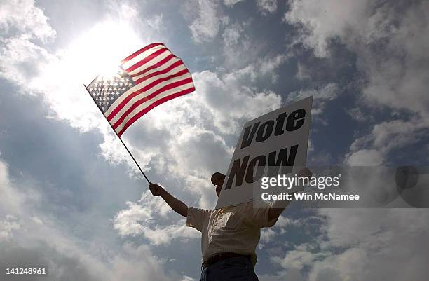 JayDanny Cooper urges Alabama residents to vote in the primary along the side of a highway March 13, 2012 in Birmingham, Alabama. As the race for...