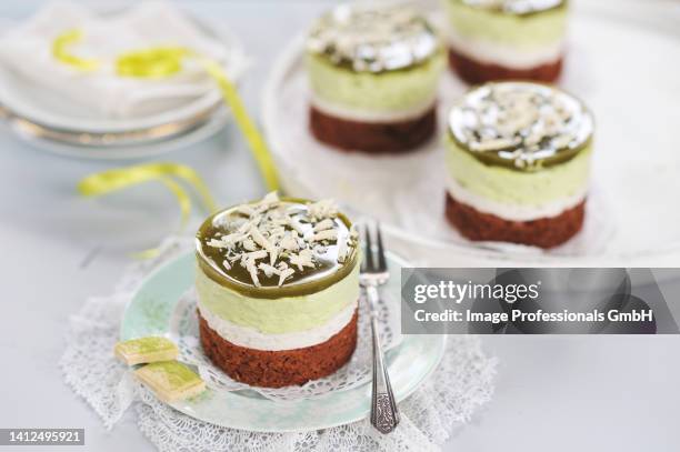 matcha cream tarts with dark chocolate bases, almond and tonka bean cream, white chocolate and matcha cream, matcha jelly, and grated white chocolate (vegan) - almond jelly stock pictures, royalty-free photos & images
