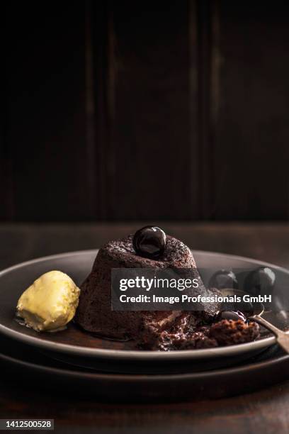 hot chocolate fondant with amaretto cherries and clotted cream - chocolate cake foto e immagini stock