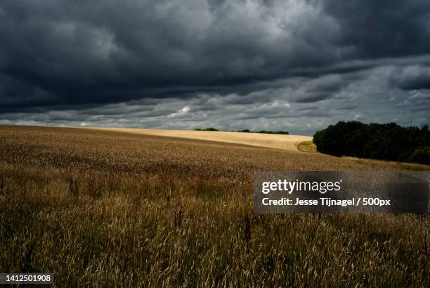 scenic view of field against storm clouds,hastiere,belgium - belgium countryside stock pictures, royalty-free photos & images