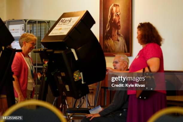 Poll worker helps a voter cast their ballot in the Kansas Primary Election at Merriam Christian Church on August 02, 2022 in Merriam, Kansas. Voters...