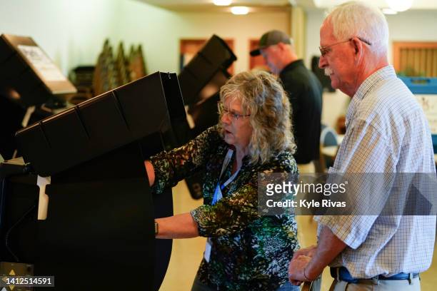 Poll worker helps a voter cast their ballot in the Kansas Primary Election at Merriam Christian Church on August 02, 2022 in Merriam, Kansas. Voters...