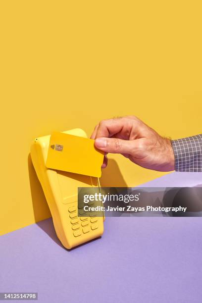 yellow credit card pos terminal on yellow and purple background - eftpos machine stock pictures, royalty-free photos & images