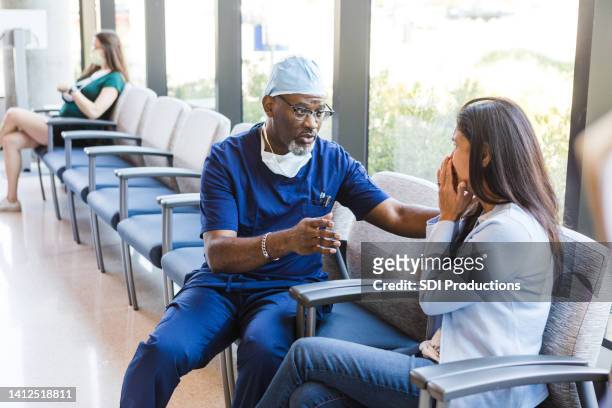 doctor comforts his patient's wife - lobbying stock pictures, royalty-free photos & images