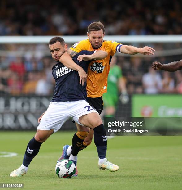 Mason Bennett of Millwall is challenged by Greg Taylor during the Carabao Cup First Round match between Cambridge United and Millwall at Abbey...