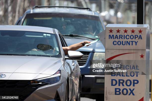 Voter places a ballot in a drop box outside of the Maricopa County Elections Department on August 02, 2022 in Phoenix, Arizona. Arizonans are heading...