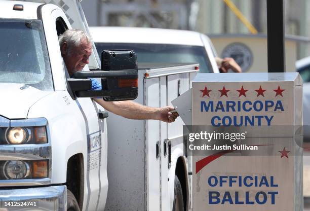 Voter places a ballot in a drop box outside of the Maricopa County Elections Department on August 02, 2022 in Phoenix, Arizona. Arizonans are heading...