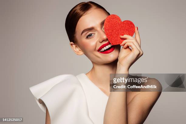 beautiful emotional woman holding present box - red lipstick stock pictures, royalty-free photos & images