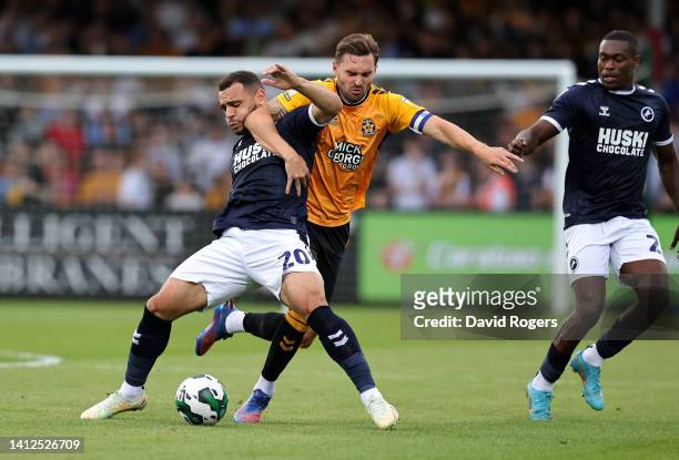 Mason Bennett of Millwall is challenged by Greg Taylor during the Carabao Cup First Round match between Cambridge United and Millwall at Abbey...
