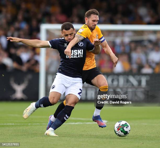 Mason Bennett of Millwall is challenged by Greg Taylor during the Carabao Cup First Round match between Cambridge United and Millwall at Abbey...