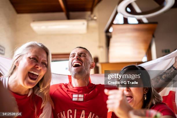 friends celebrating english team winning in a bar - england fans stockfoto's en -beelden