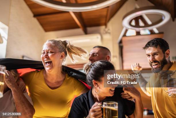 happy german team fans celebrating in a bar - german culture stock pictures, royalty-free photos & images