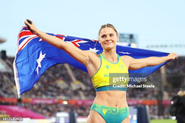 Nina Kennedy of Team Australia celebrates with their countries flag after winning Gold medal in the Women's Pole Vault Final on day five of the...