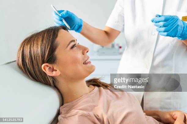 young woman with correction dots on the face at the cosmetologist - plasma stockfoto's en -beelden