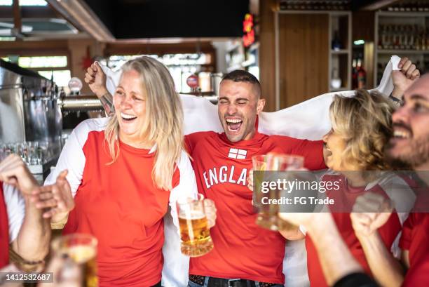 friends celebrating english team winning in a bar - british pub stock pictures, royalty-free photos & images