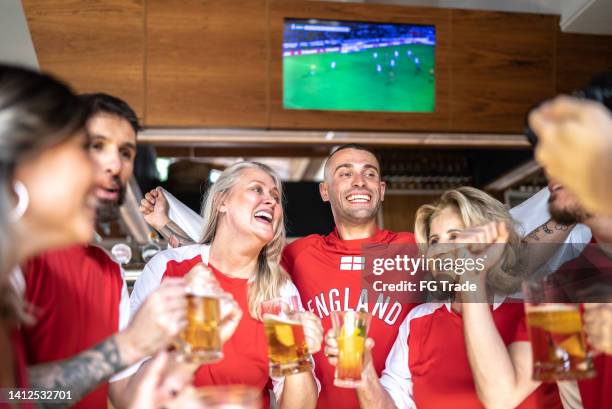 freunde feiern den sieg des englischen teams in einer bar - british pub stock-fotos und bilder