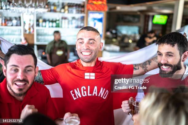 friends celebrating english team winning in a bar - english pub stock pictures, royalty-free photos & images