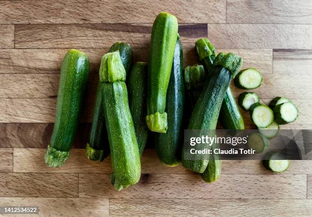 fresh zucchini on wooden background - mergpompoen stockfoto's en -beelden