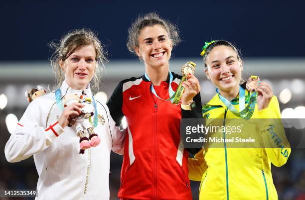 Silver medalist Sophie Hahn of Team England, Gold medalist Olivia Breen of Team Wales and Bronze medalist Rhiannon Clarke of Team Australia celebrate...