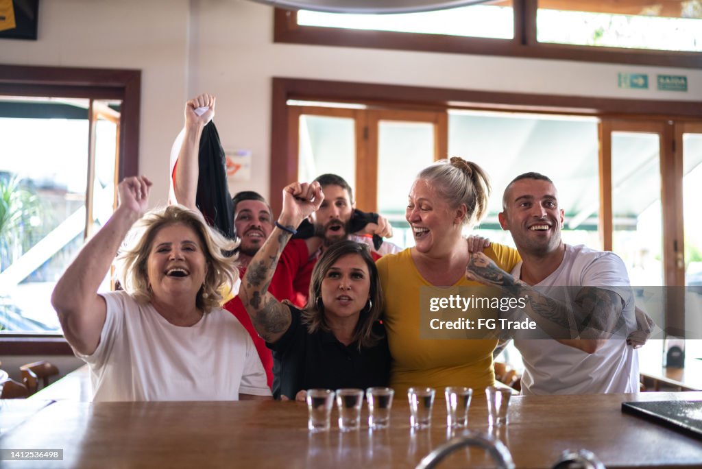 Amigos celebrando la victoria del equipo alemán en un bar